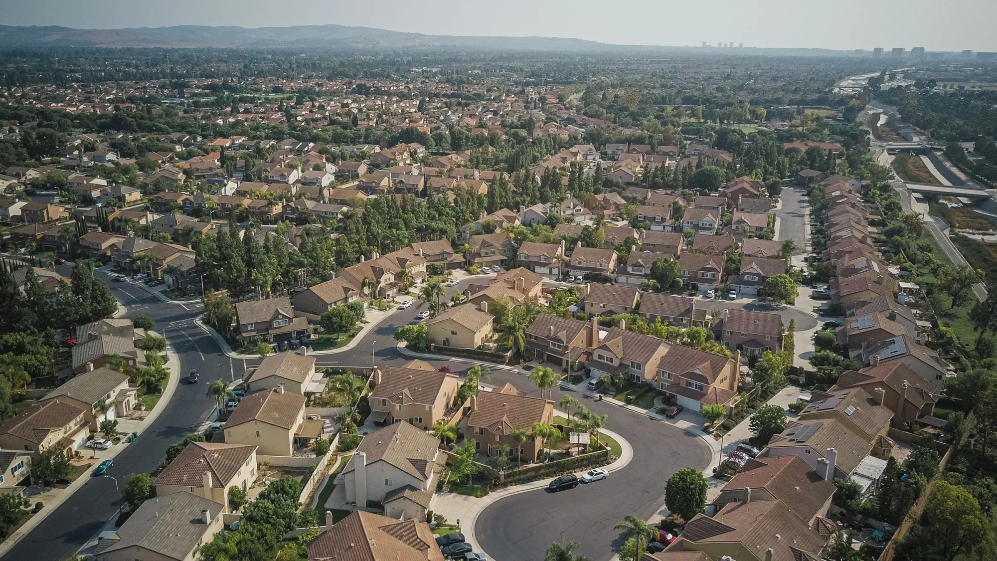 A neighborhood of houses along curving streets, seen from the air.